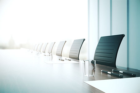 chairs pushed against a desk in a boardroom