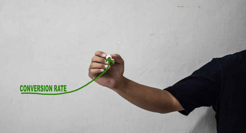 man drawing upward-trending line under the word "conversions"