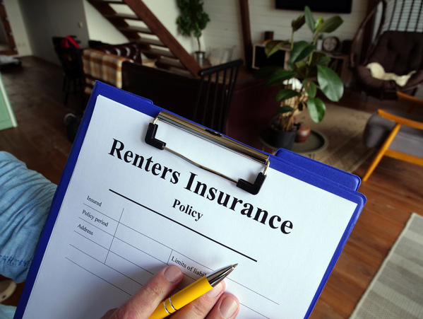 Person holding a renters insurance policy form to sign